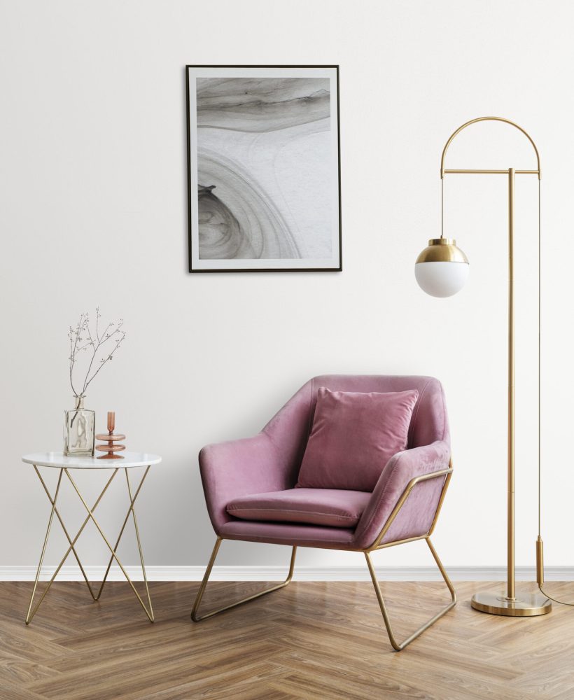 Picture frame with abstract art by a pink velvet armchair